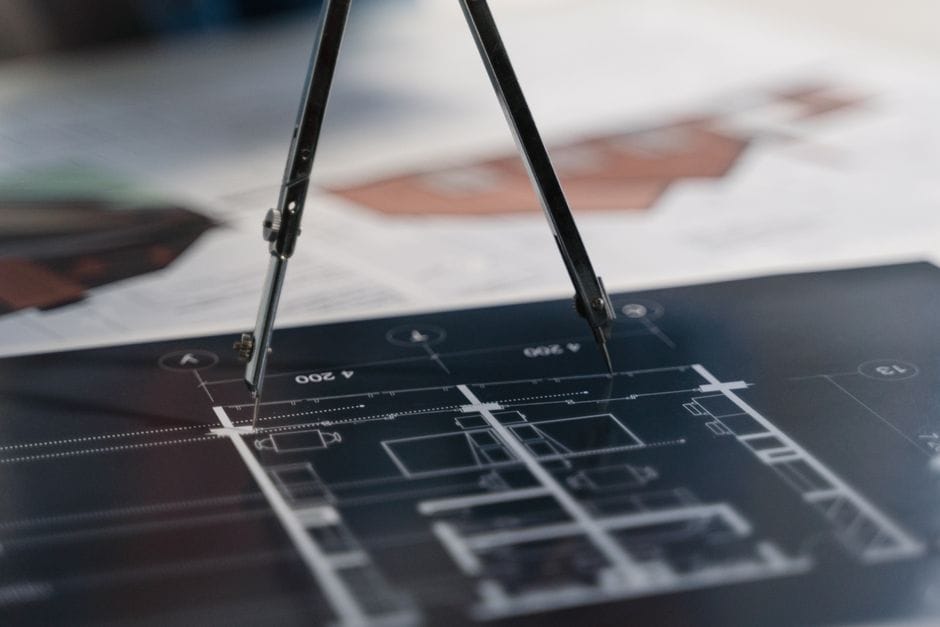 A compass on architectural blueprints, showcasing planning and measurement details